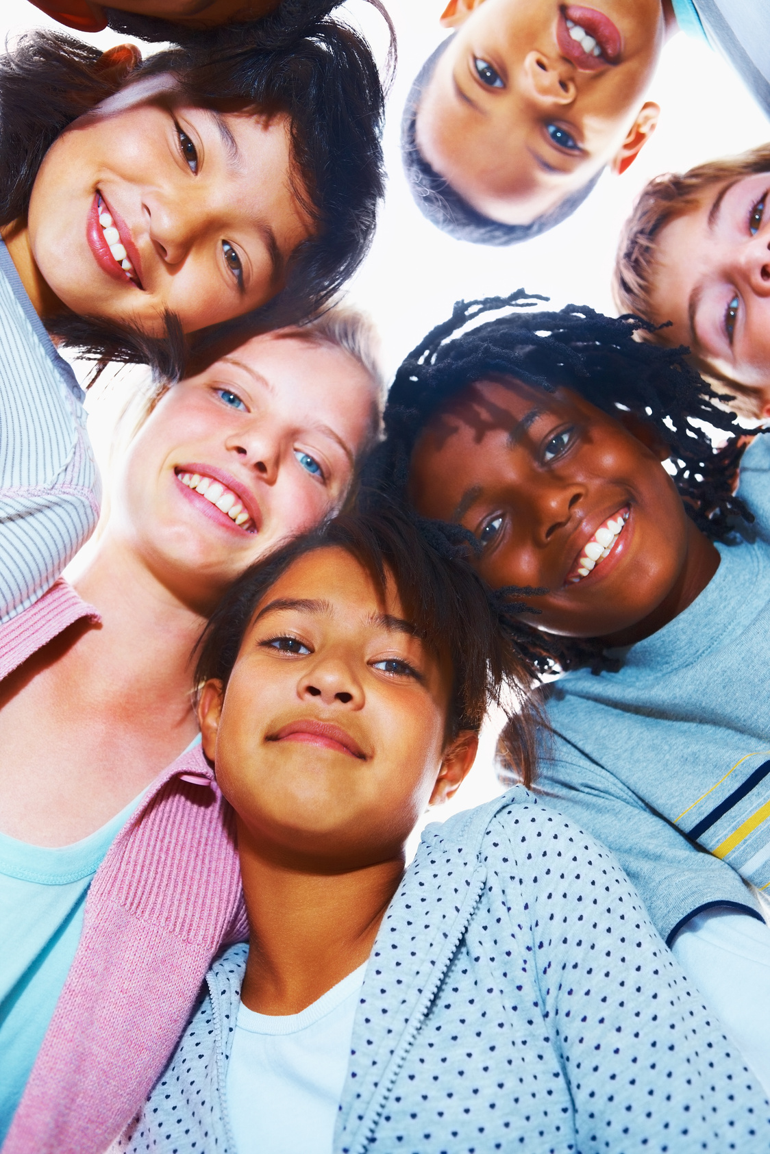 Group of middle school children looking down and smiling